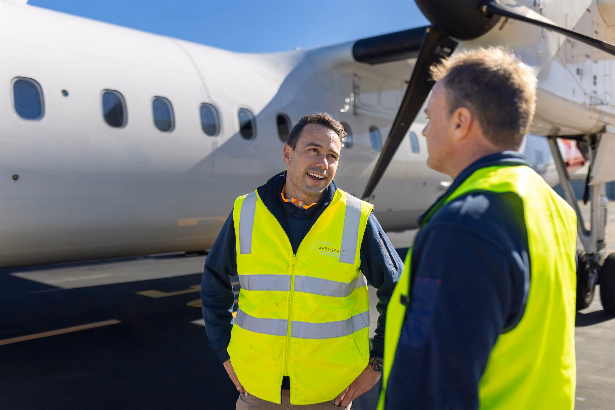 Sigma aircraft maintenance engineers beside a regional turboprop